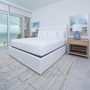 Retreat to the king master suite with cozy bedding and drift off to the sound of the waves from the balcony