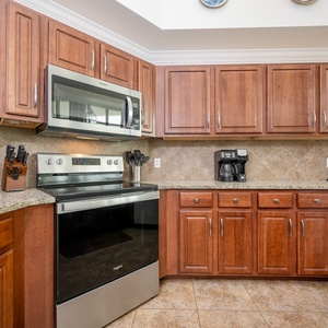 Modern kitchen featuring stainless appliances, granite countertops, and coffee station, perfect for your culinary adventures