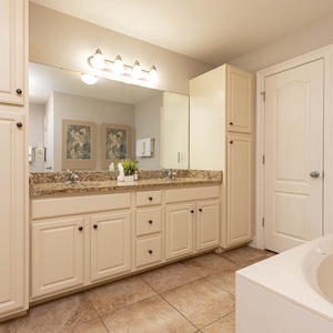 The master bathroom features elegant granite countertops, ample storage, and a relaxing jetted tub for a refreshing retreat