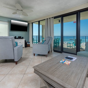 This living area features cozy seating, a queen sofa-sleeper, large TV, and a breathtaking view of the beach