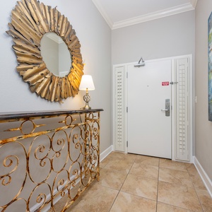 This entryway features a stylish sunburst mirror, a decorative console table, and vibrant artwork, welcoming guests warmly