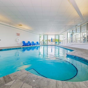 Relax in this indoor pool area with bright blue chairs and a refreshing view, perfect for unwinding after a day of fun