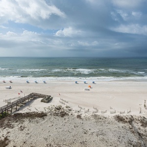 Bask in the fresh air from the balcony while enjoying views of the beach and colorful beach umbrellas below