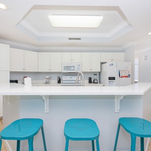 Savor your morning coffee on the vibrant bar stools, enjoying the cheerful ambiance of this welcoming kitchen space