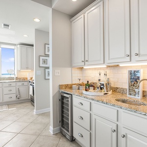 The wet bar area features the same elegant design and a wine cooler, perfect for entertaining