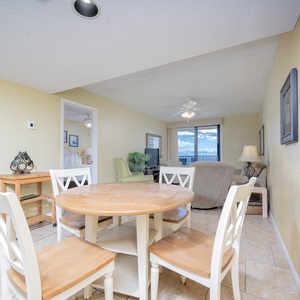 Living area featuring a cozy dining table and a view of the balcony through large windows