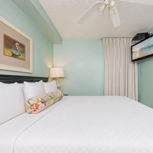 Fluffy pillows invite you to relax in the king suite for a calm movie night after a fun day at the beach