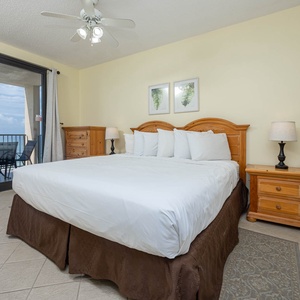 Relax in the spacious master bedroom featuring a king bed, elegant decor, and direct access to the beachfront balcony