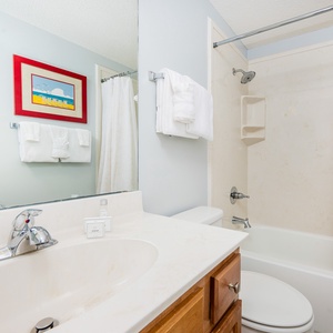 Refresh in this guest bathroom featuring a large mirror, ample counter space, and a relaxing tub-shower for your comfort