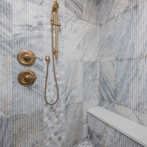 Experience rejuvenation under the elegant rainfall showerhead in the master, surrounded by beautiful stone details