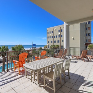 This inviting outdoor space features a dining table and colorful lounge chairs, perfect for enjoying the beachfront view