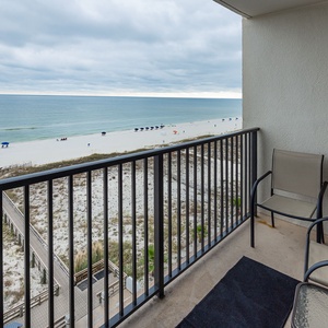 Enjoy breathtaking views from the balcony, featuring comfortable seating and a serene beach just steps away