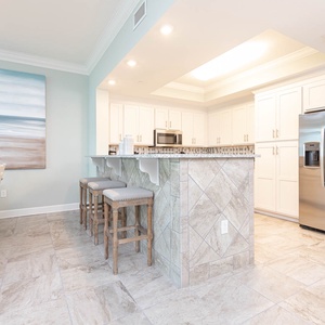 Pull up a cushioned stool at the breakfast bar and sip morning coffee in this inviting kitchen area