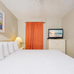 Orange curtains frame your restful guest suite where you relax with a show on the dresser TV