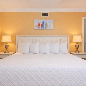 Drift off into restful sleep on a plush king bed in the guest suite, embraced by the soothing vibe of warm, coastal hues