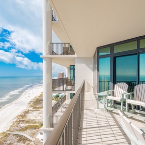 Spacious balcony with inviting chairs and breathtaking views of the pristine pristine beach and sparkling waters