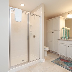 Enjoy a relaxing shower after a day at the beach in this guest bath with stylish cabinetry and spacious vanity