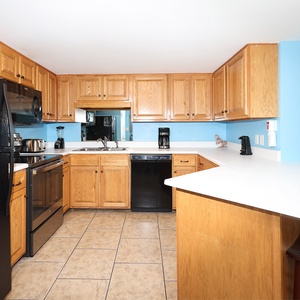 Sleek kitchen featuring oak cabinetry, a breakfast bar, and black appliances, perfect for casual dining and entertaining