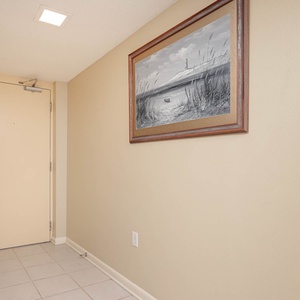 Welcoming entryway featuring a neutral color palette, tile flooring, and a framed coastal artwork enhancing the atmosphere