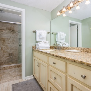 Discover the stylish master bath featuring a spacious vanity, modern lighting, and a glass-enclosed walk-in shower
