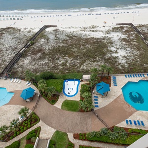 Relax by the inviting pools surrounded by lush landscaping, with easy access to the beach just steps away