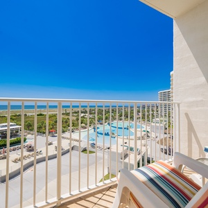 Enjoy vibrant views of the sparkling pool and lush landscape from the inviting balcony with colorful seating