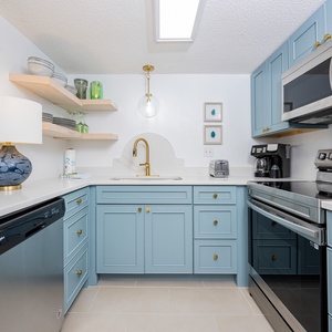 The kitchen features light blue cabinets, stainless appliances, and elegant decor, perfect for dining or entertaining