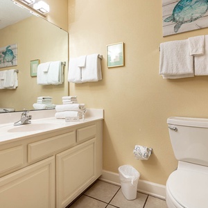 Guest bathroom featuring a spacious vanity, decorative turtle artwork, and a tub/shower combo for a refreshing experience