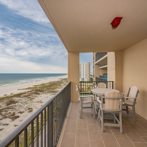 Savor meals at the outdoor table, enjoying refreshing breezes and views of the shoreline from your spacious balcony