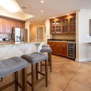 This kitchen features rich wooden cabinetry, granite countertops, and a wine cooler, perfect for entertaining