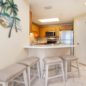 Gather around the breakfast bar, enjoying a casual meal while admiring the beach-themed decor and kitchen amenities