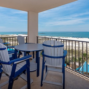 Enjoy your morning coffee at the balcony table with sweeping views of the beach and turquoise waters