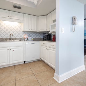 Bright and inviting kitchen featuring white cabinets, granite countertops, a Keurig and a coffee maker for the perfect brew