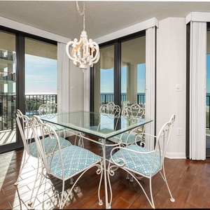 Savor the beach vibe while gathering around the glass dining table, soaking in the natural light and scenic views