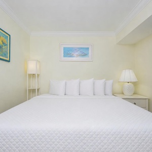 Charming king suite with fluffy pillows and soft linens for relaxation on the beach