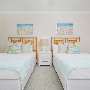 Relax in this guest bedroom featuring two queen beds with coastal decor to brighten your stay