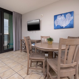 Have a family meal or game night around the dining table in the living space with a beachfront balcony view