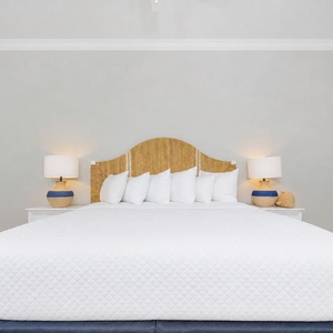 Rest in this king suite featuring a cozy bed, fluffy pillows, and a relaxing vibe