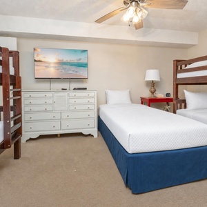 Guest suite with twin and two twin bunk beds offers cozy sleeping spots and a TV for evening entertainment