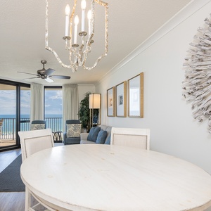 Bright dining area featuring a round table, stylish chandelier, and a view of the gulf through large sliding glass doors