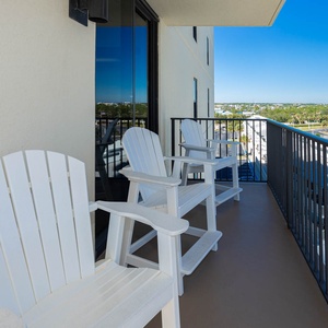 Adirondack chairs line the balcony, offering a perfect spot to relax and enjoy views of the surrounding area