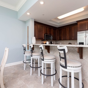 Chat and enjoy cocktails gathered around the inviting breakfast bar, with coastal decor enhancing your experience