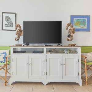 Cozy seating with vibrant green chairs complements a TV stand adorned with beach decor and artwork, enhancing relaxation