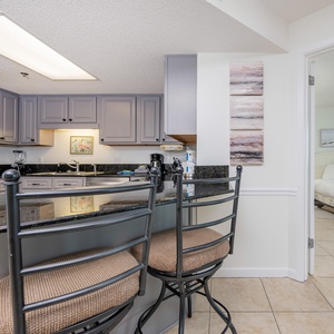 Modern kitchen with granite countertops, a breakfast bar with seating, and stainless appliances