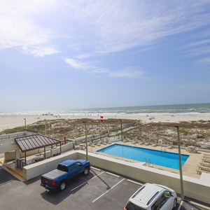 Enjoy stunning beachfront views from this inviting space, complete with a sparkling pool and easy beach access