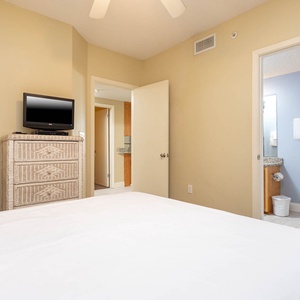 Relax in this inviting guest bedroom featuring a queen bed, a TV, and easy access to the adjoining bathroom