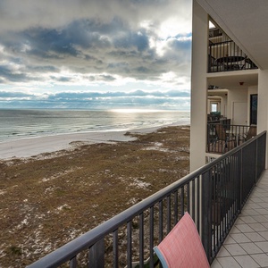 Balcony view showcasing the tranquil beach with gentle waves and white sand, perfect for relaxation and enjoying the scenery