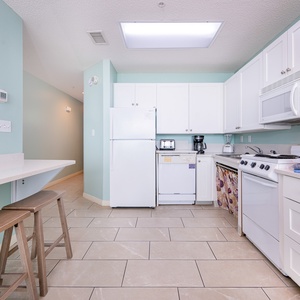 The kitchen area features lower counters and accessible appliances with a bar area for convenience