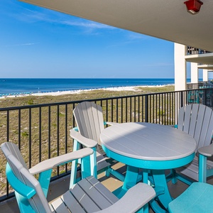 Colorful chairs circle the table on your balcony as you watch the coast stretch into the distance