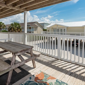 This outdoor deck features a picnic table and vibrant decor, perfect for enjoying a relaxing meal with a view